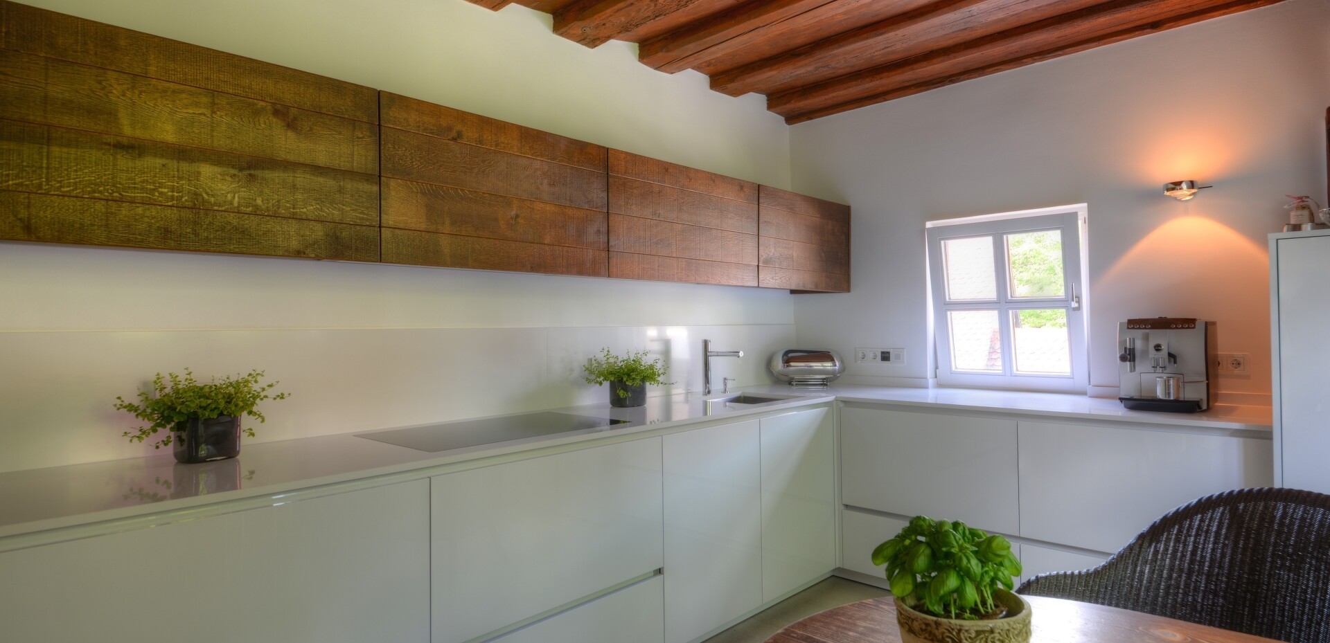 Die restliche Küche haben wir sehr zurückhaltend gestaltet. Die Wirkung der denkmalgeschützten Balkendecke konnte so perfekt in Szene gesetzt werden.