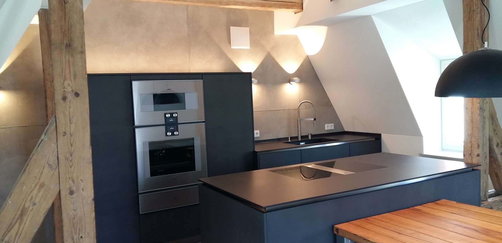 Der Esstisch ist an den Kochblock angesetzt. Im rückwärtigen Bereich des Kochblocks befinden sich 2 Geschirrschränke.