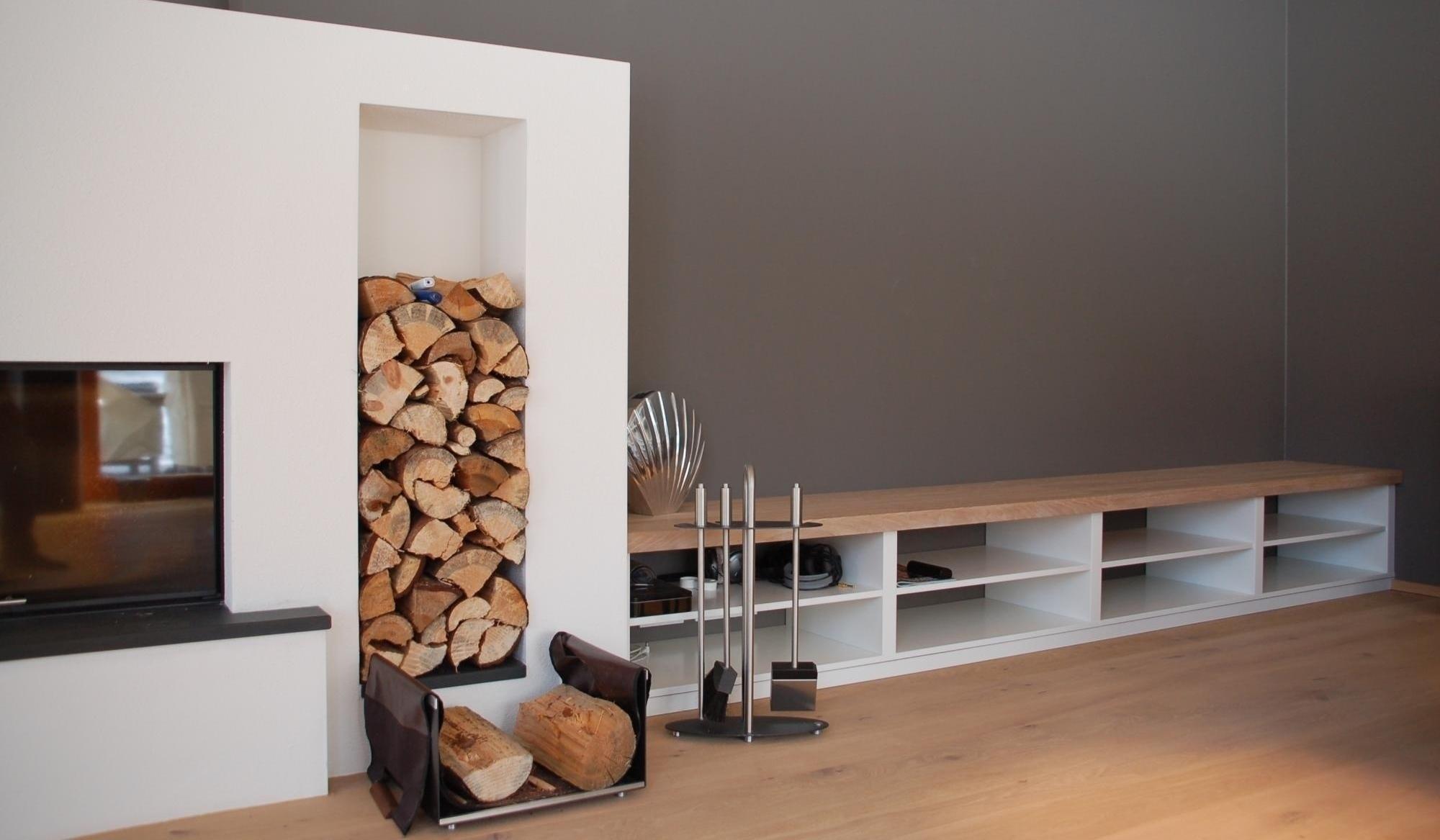 Modernes Wohnzimmer mit Kamin, gestapeltem Brennholz und Regalwand