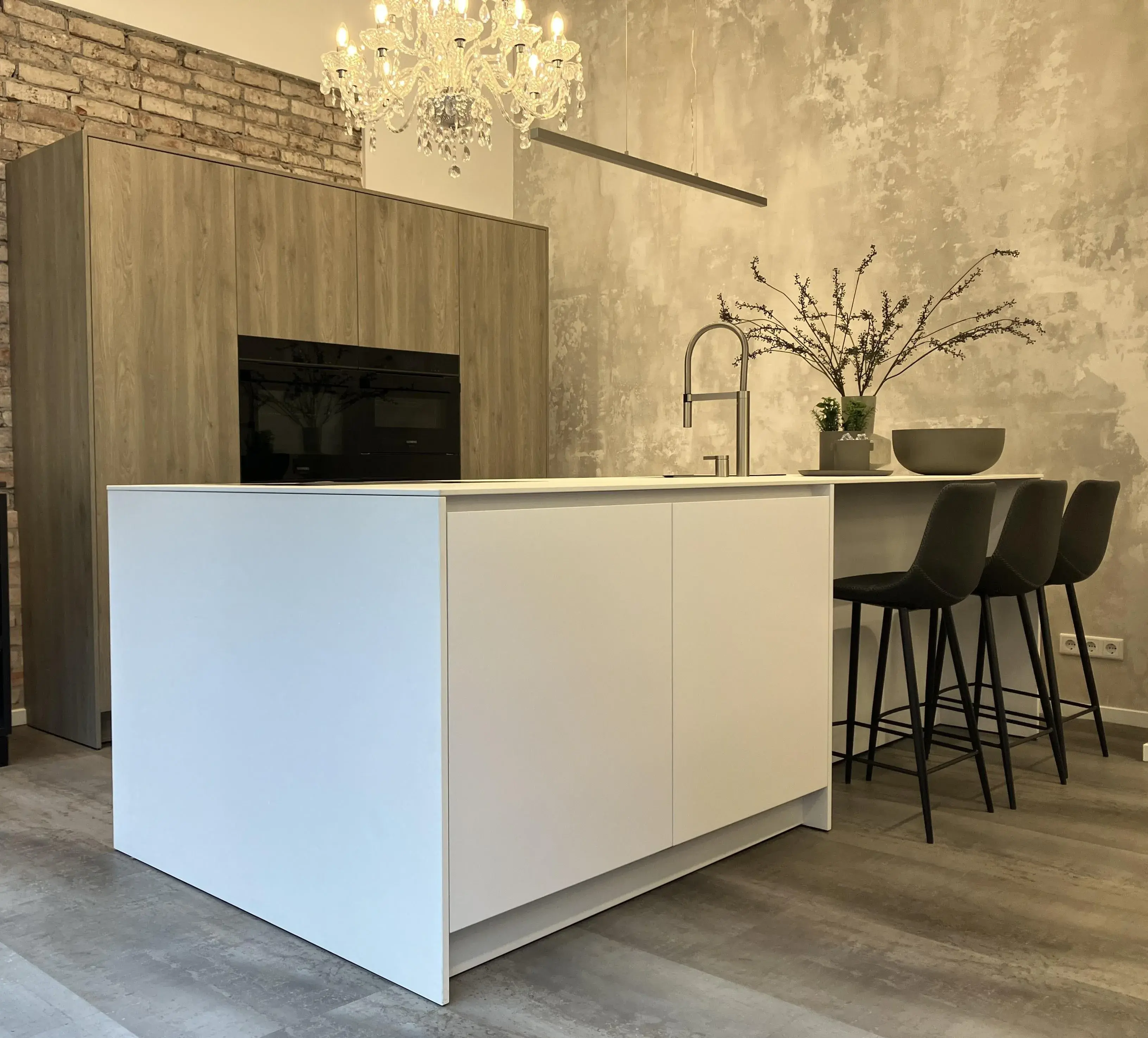 Moderne Küche mit weißer Kochinsel, Holzschränken und drei Barhockern.