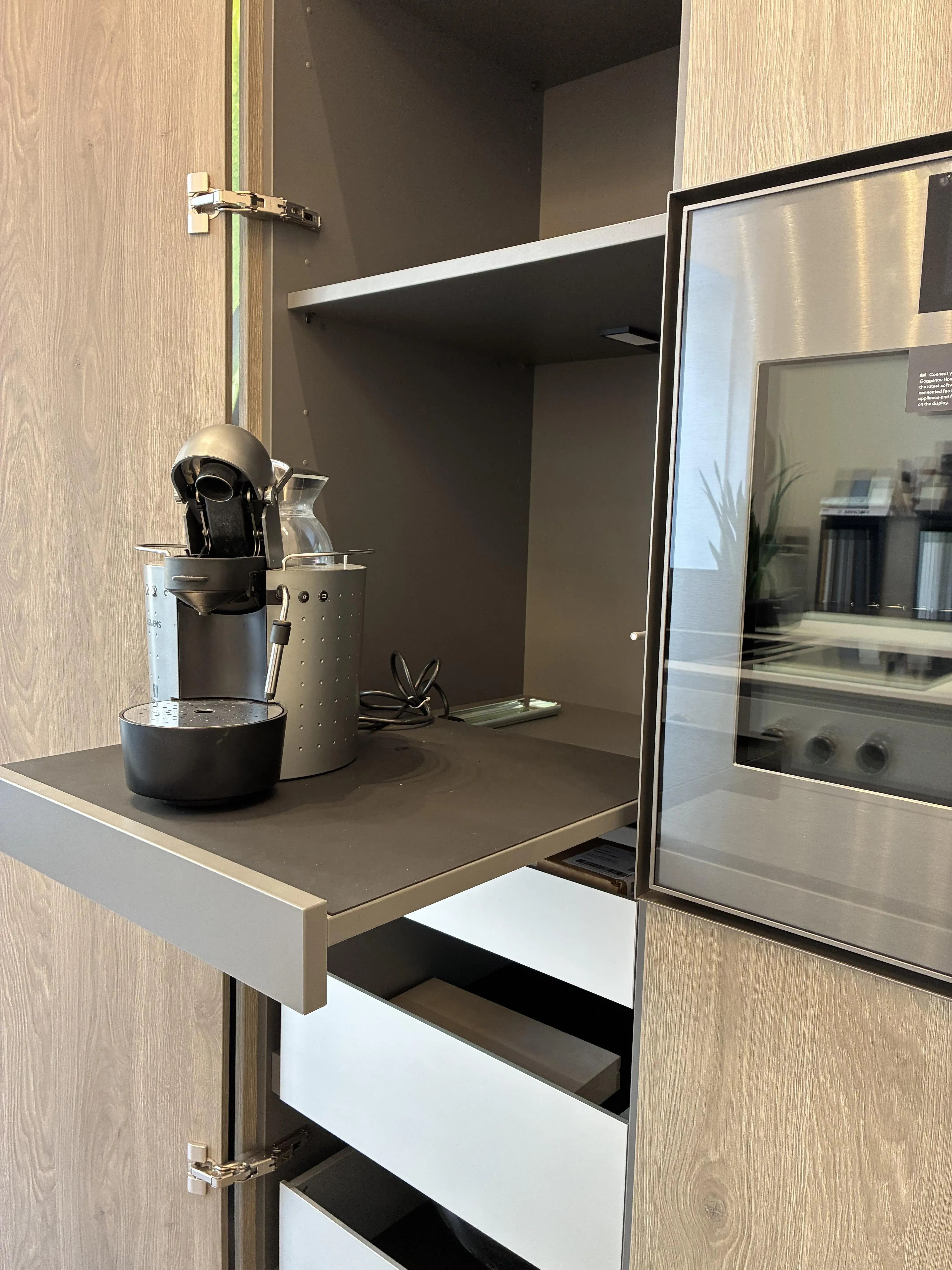 Kaffeemaschine auf ausziehbarem Regal in modernem Küchenschrank